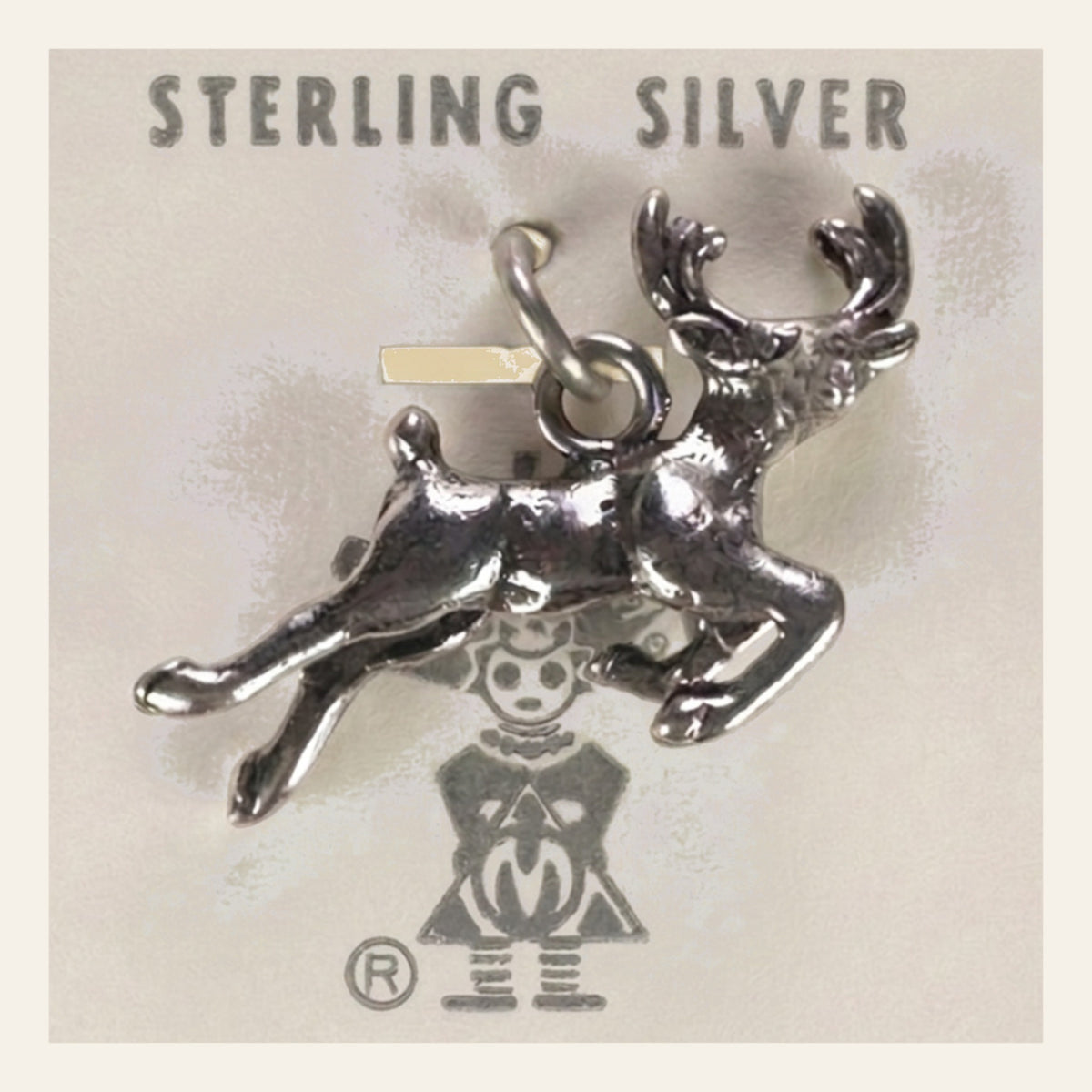 Leaping Elk Charm in Sterling Silver, Vintage Maisel's New Old Stock, shown on a cream background