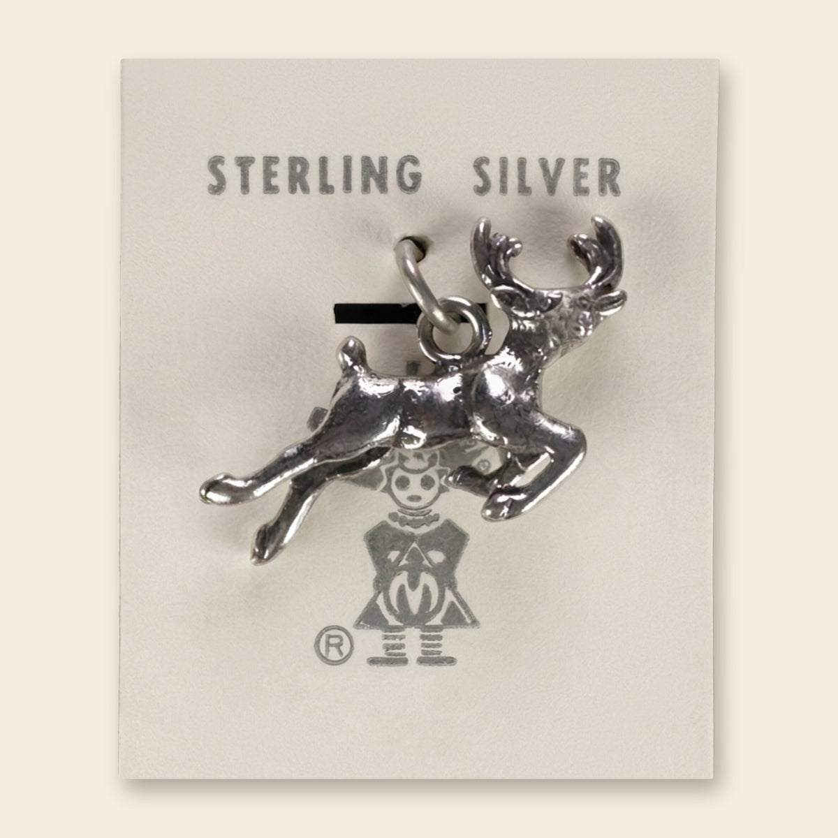 Leaping Elk Charm in Sterling Silver, Vintage Maisel's New Old Stock, shown on an ivory background