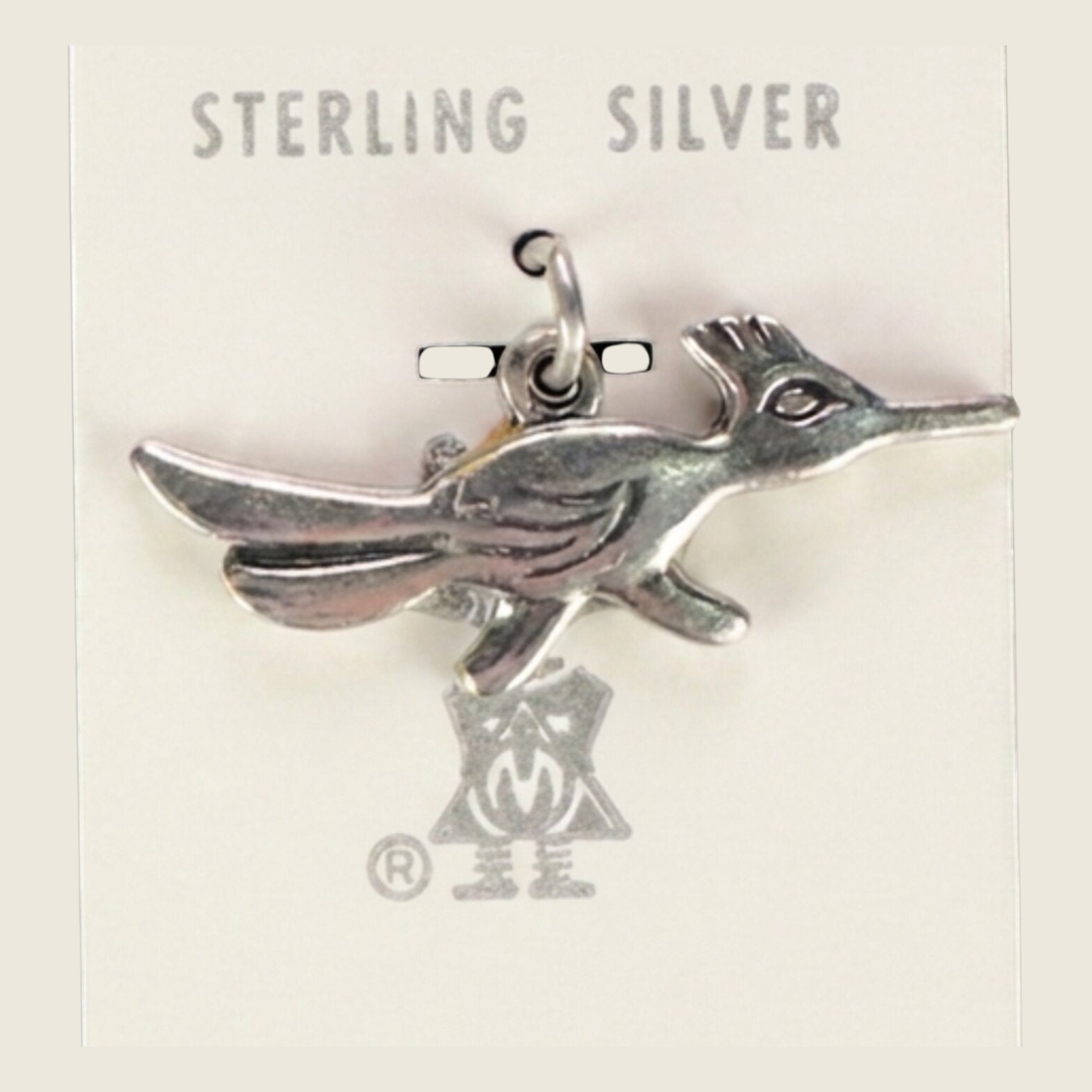 Vintage Maisel's sterling silver roadrunner charm, shown on a bone linen background