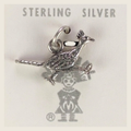Vintage Maisel's textured sterling silver roadrunner charm, shown on a bone linen background