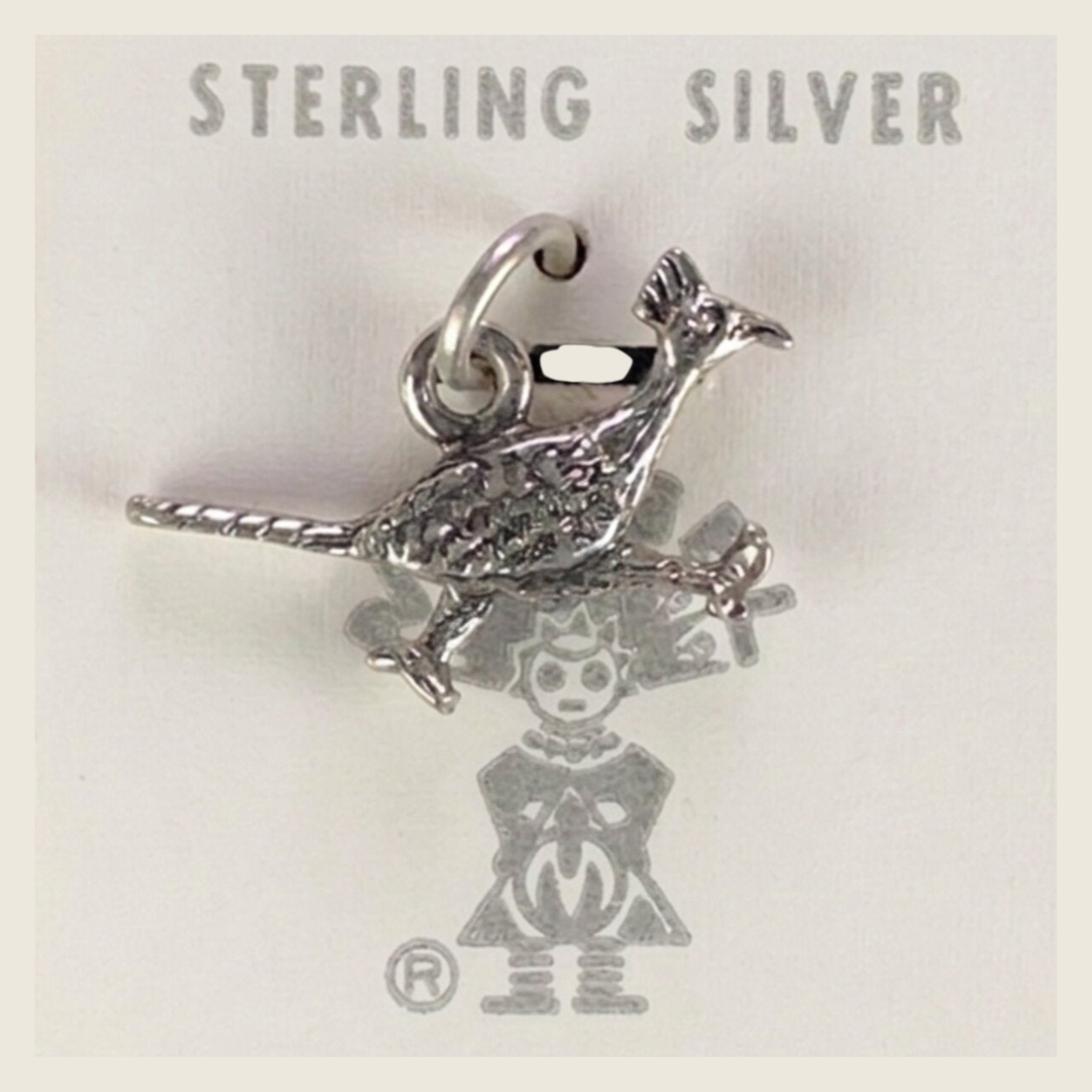Vintage Maisel's textured sterling silver roadrunner charm, shown on a bone linen background