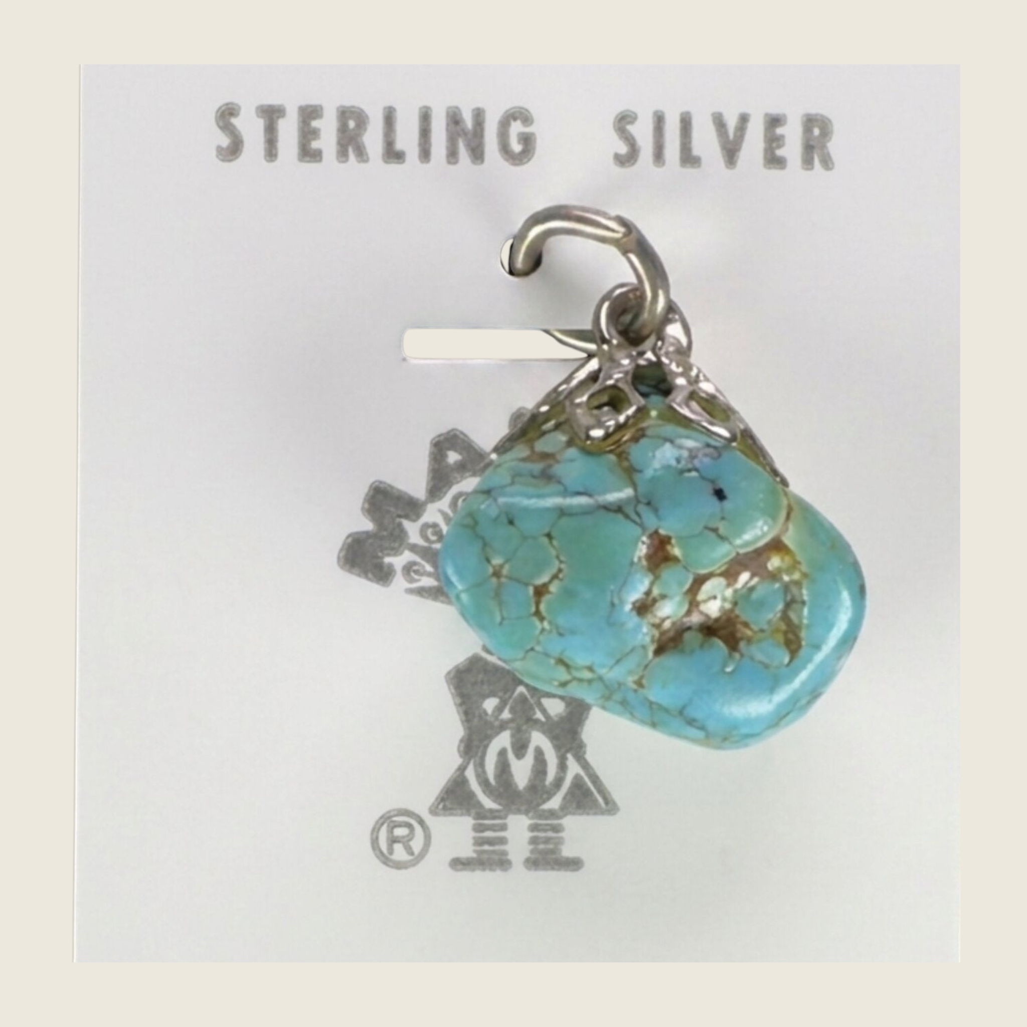Vintage Maisel's turquoise nugget pendant in sterling silver with brown matrix, shown on a bone linen background