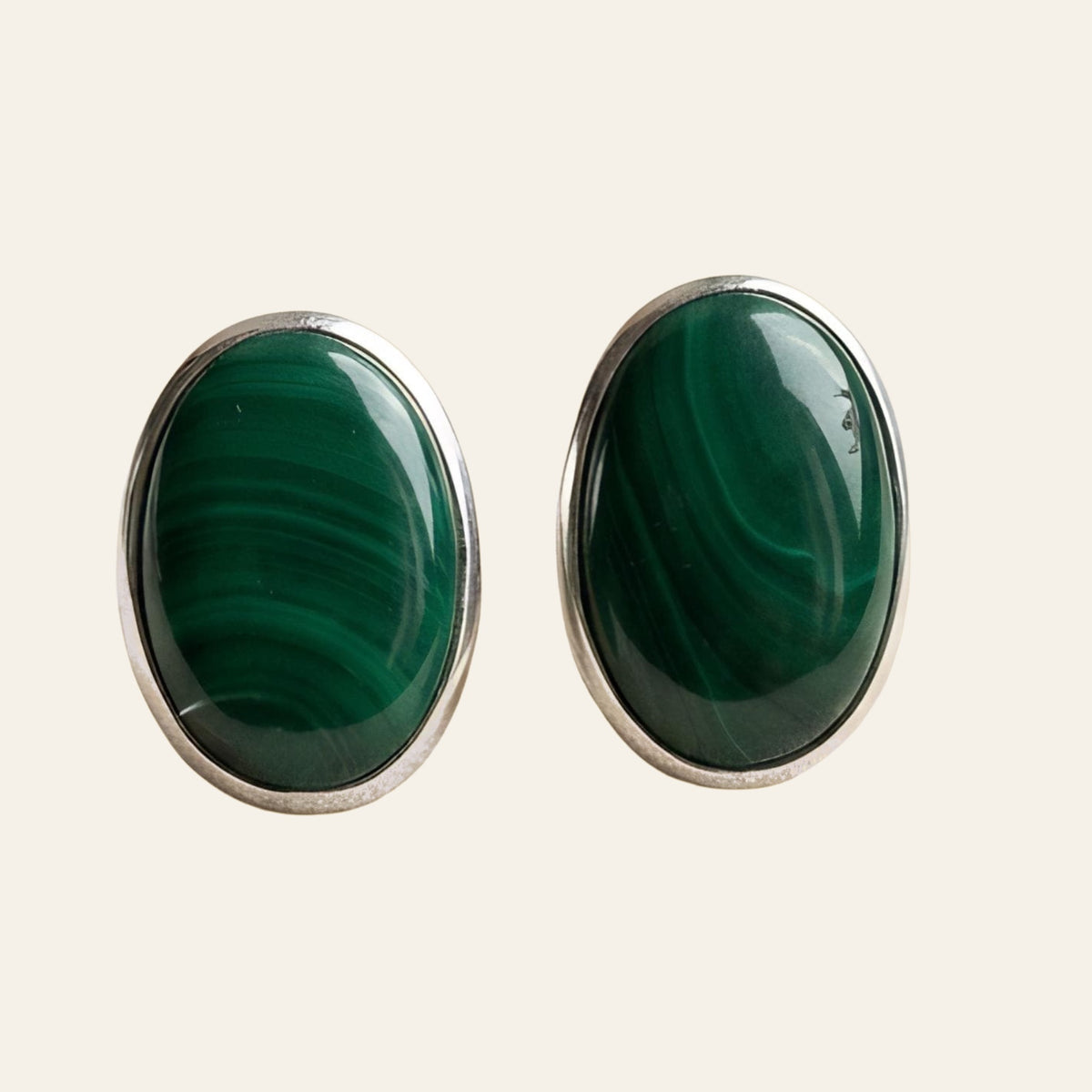 Malachite Oval Stud Earrings in Sterling Silver, shown on a cream background