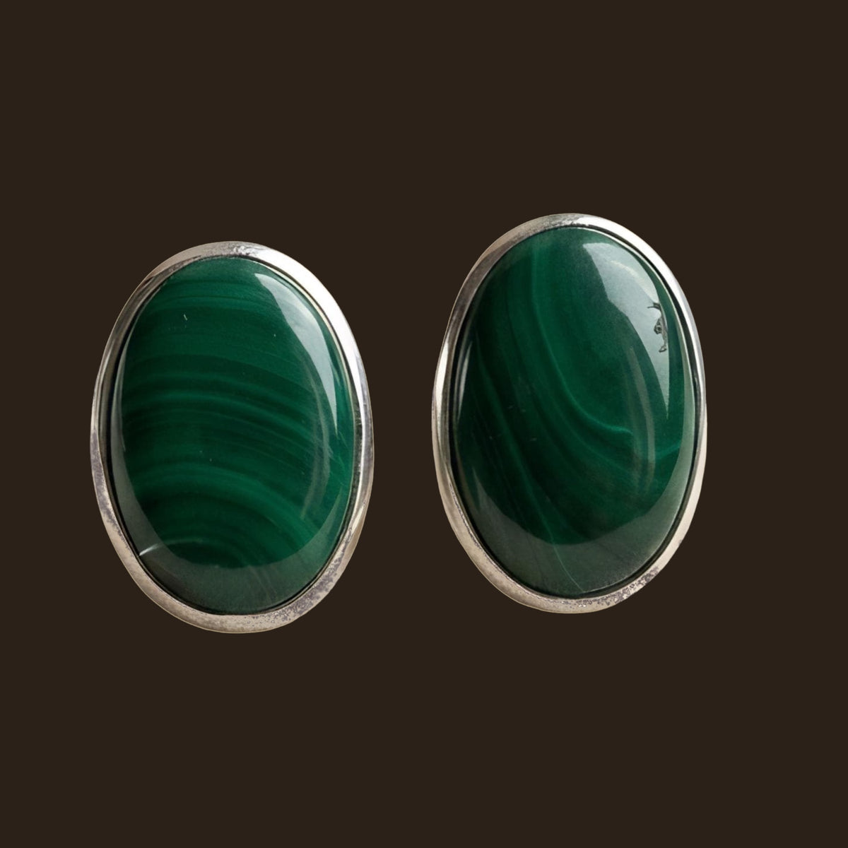 Malachite Oval Stud Earrings in Sterling Silver, shown on an espresso background