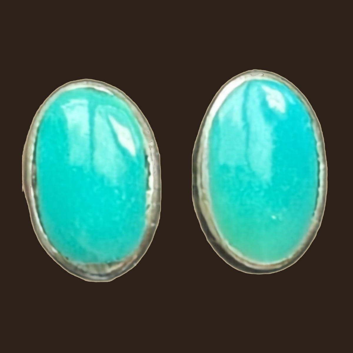 Natural Turquoise Oval Stud Earrings in Sterling Silver, shown on an espresso background