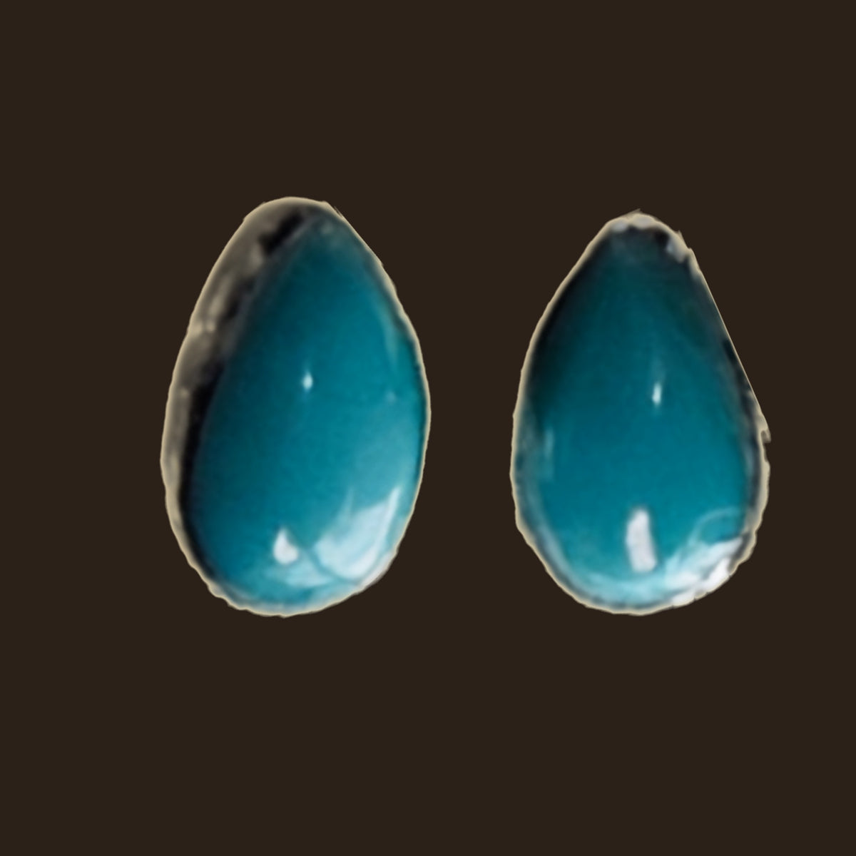Natural Turquoise Teardrop Stud Earrings in Sterling Silver, shown on an espresso background
