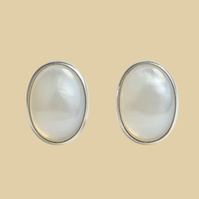 Opal Oval Stud Earrings in Sterling Silver, shown on a desert plaster background