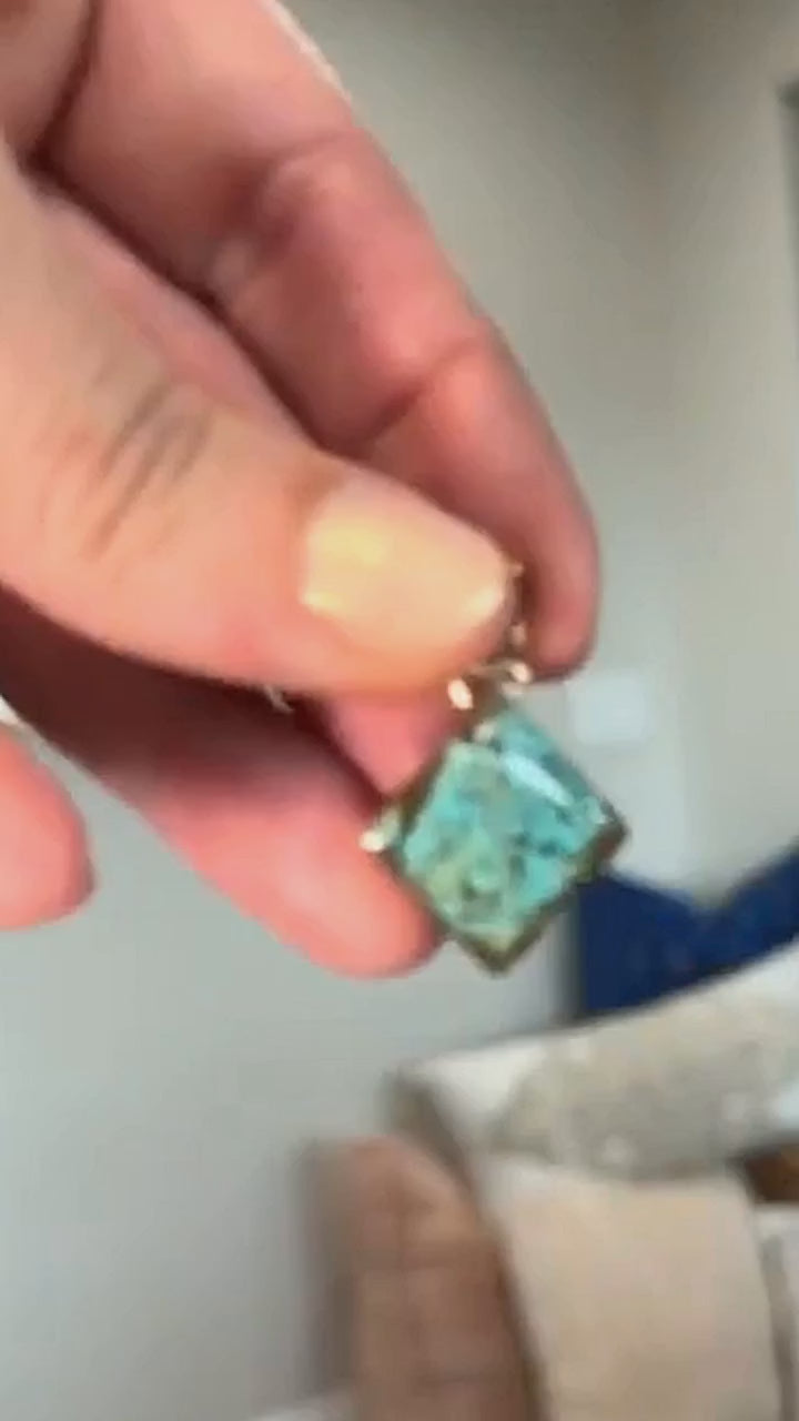 Number 8 spiderweb turquoise pendant in sterling silver, held in hand