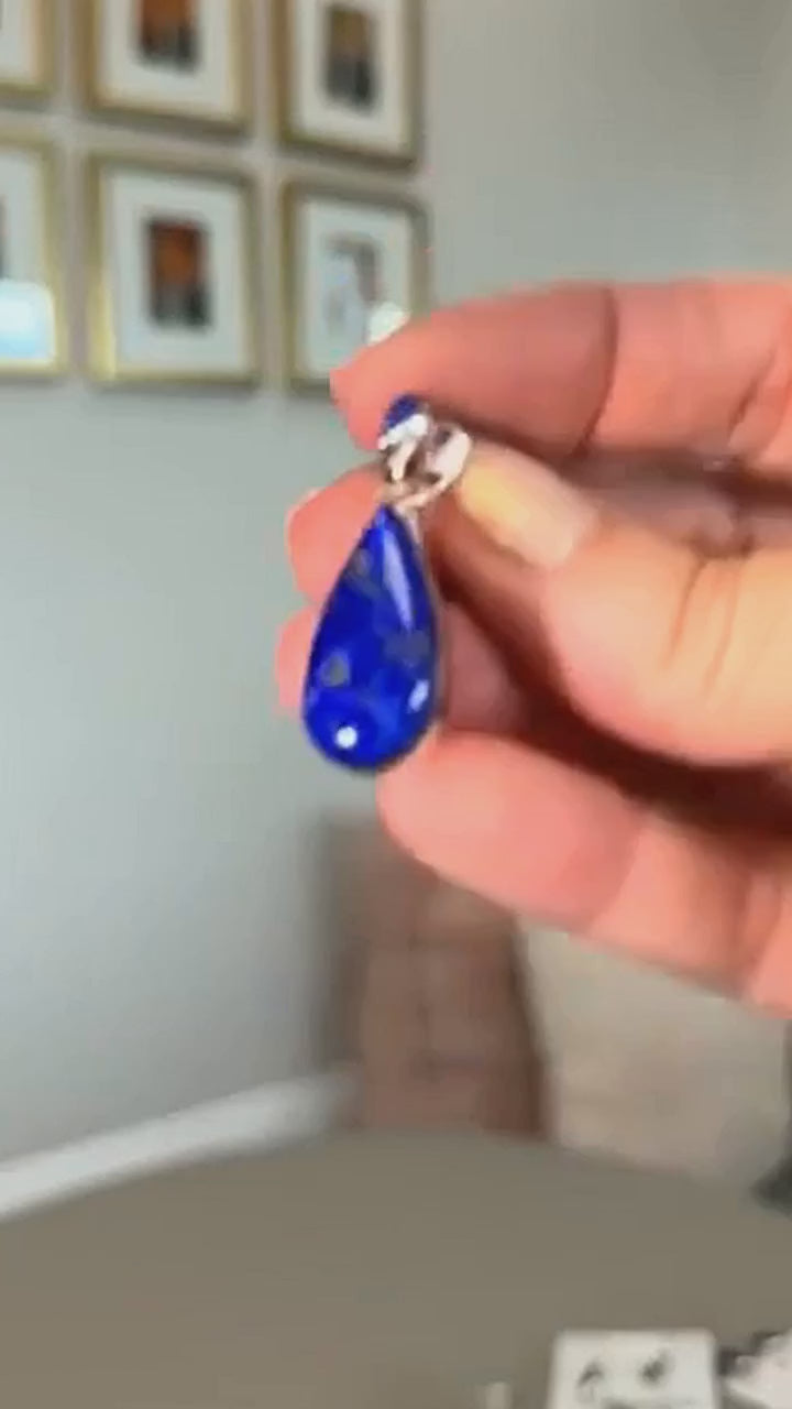 Lapis lazuli teardrop pendant in sterling silver, held in hand
