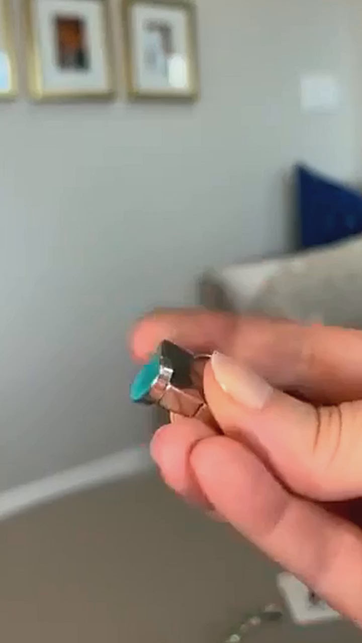 Oval turquoise ring in sterling silver, turned to show the stone and band