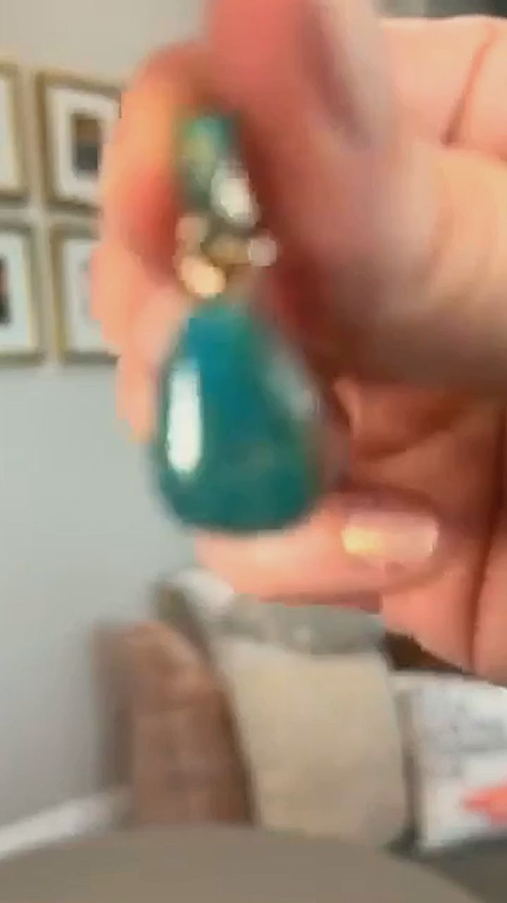 Fox turquoise teardrop pendant in sterling silver, held in hand