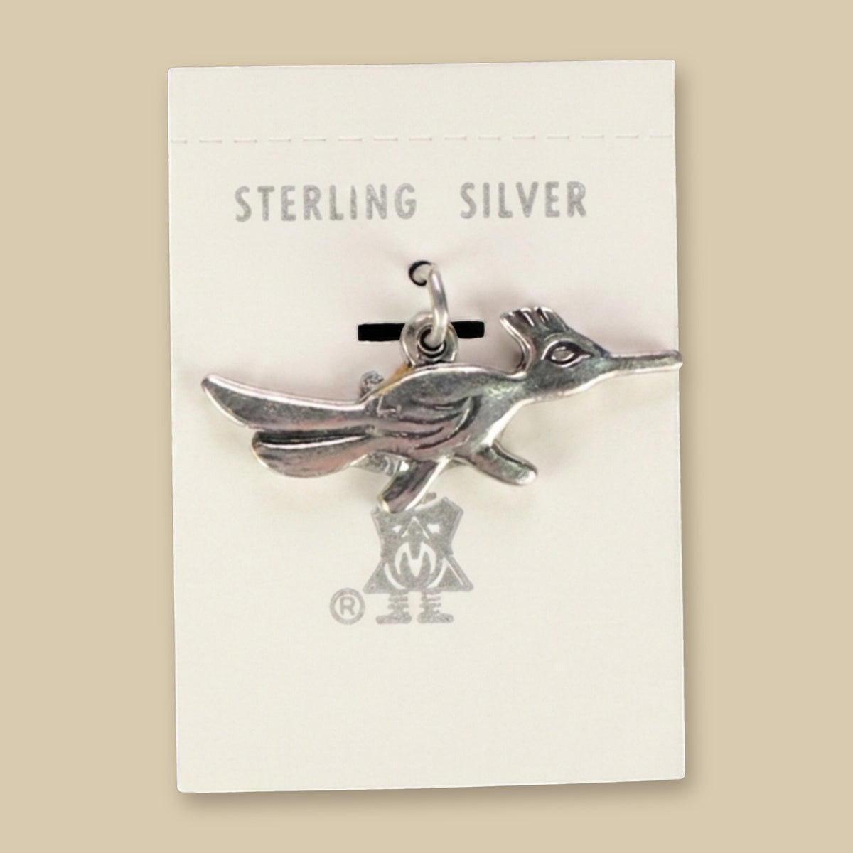 Roadrunner Charm in Sterling Silver, Vintage Maisel's New Old Stock, shown on a sand background