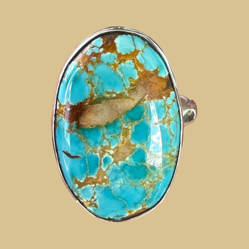 Royston turquoise ring in sterling silver, close-up of the blue-green oval cabochon with golden brown matrix