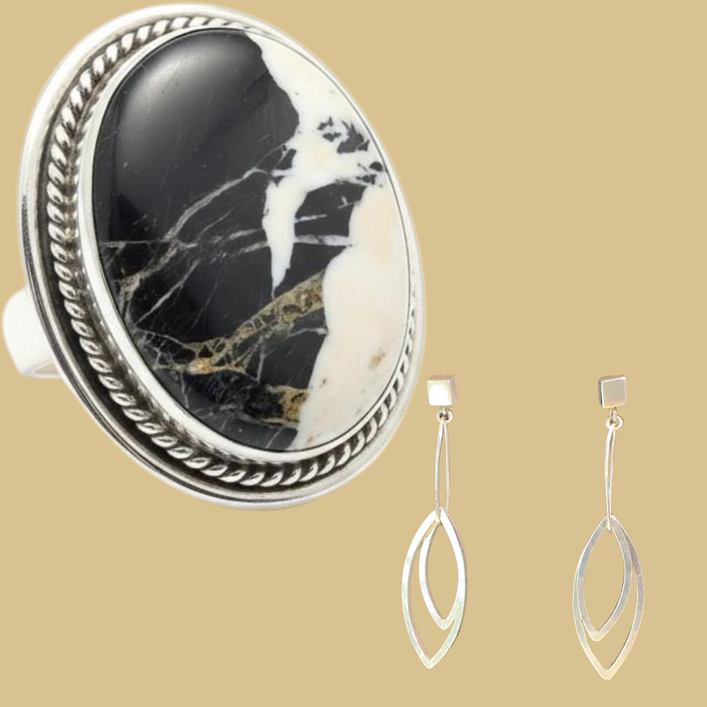 White buffalo ring and leaf dangle earrings jewelry set in sterling silver, shown on a warm sand background