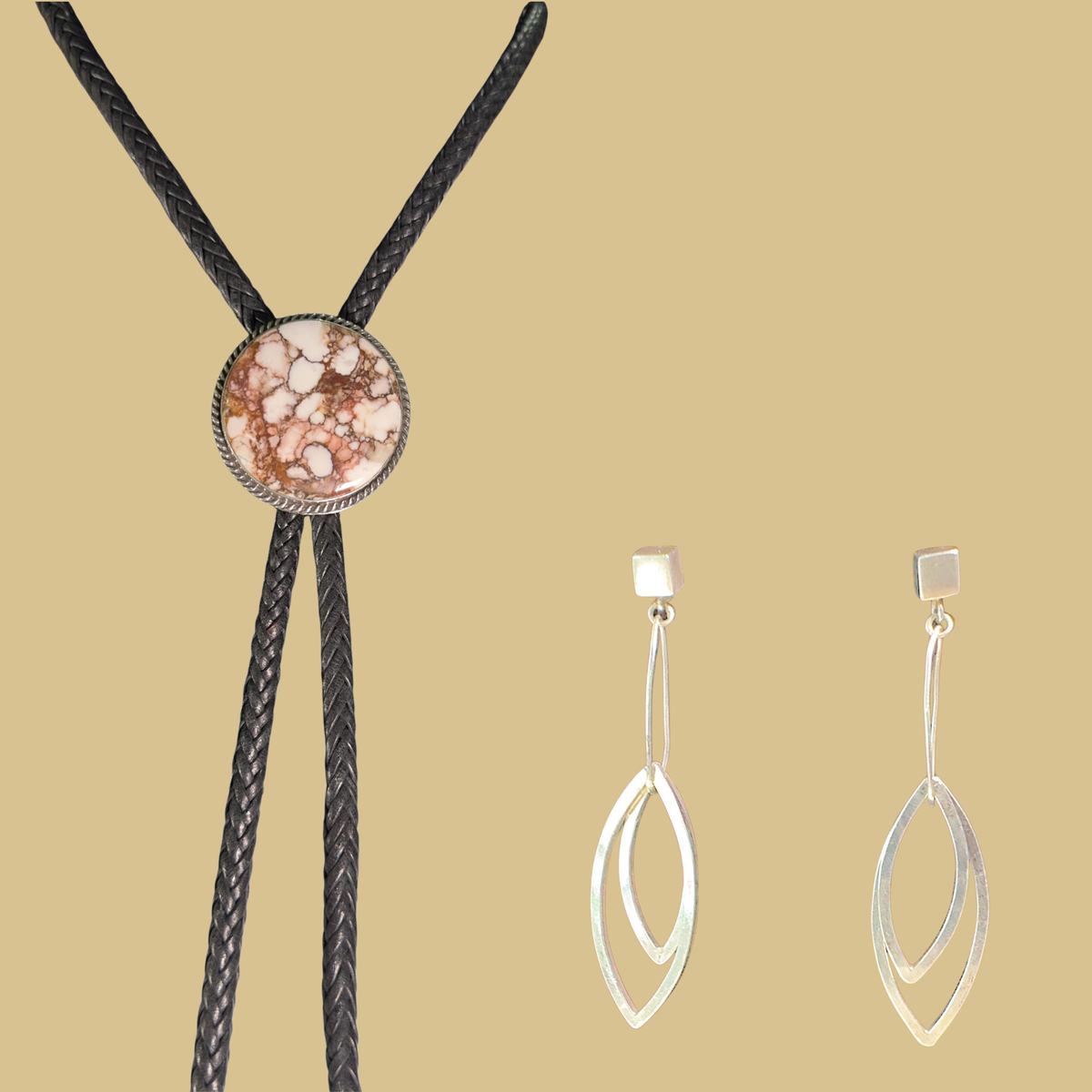 Wild horse bolo tie and leaf dangle earrings jewelry set in sterling silver, shown on a warm sand background