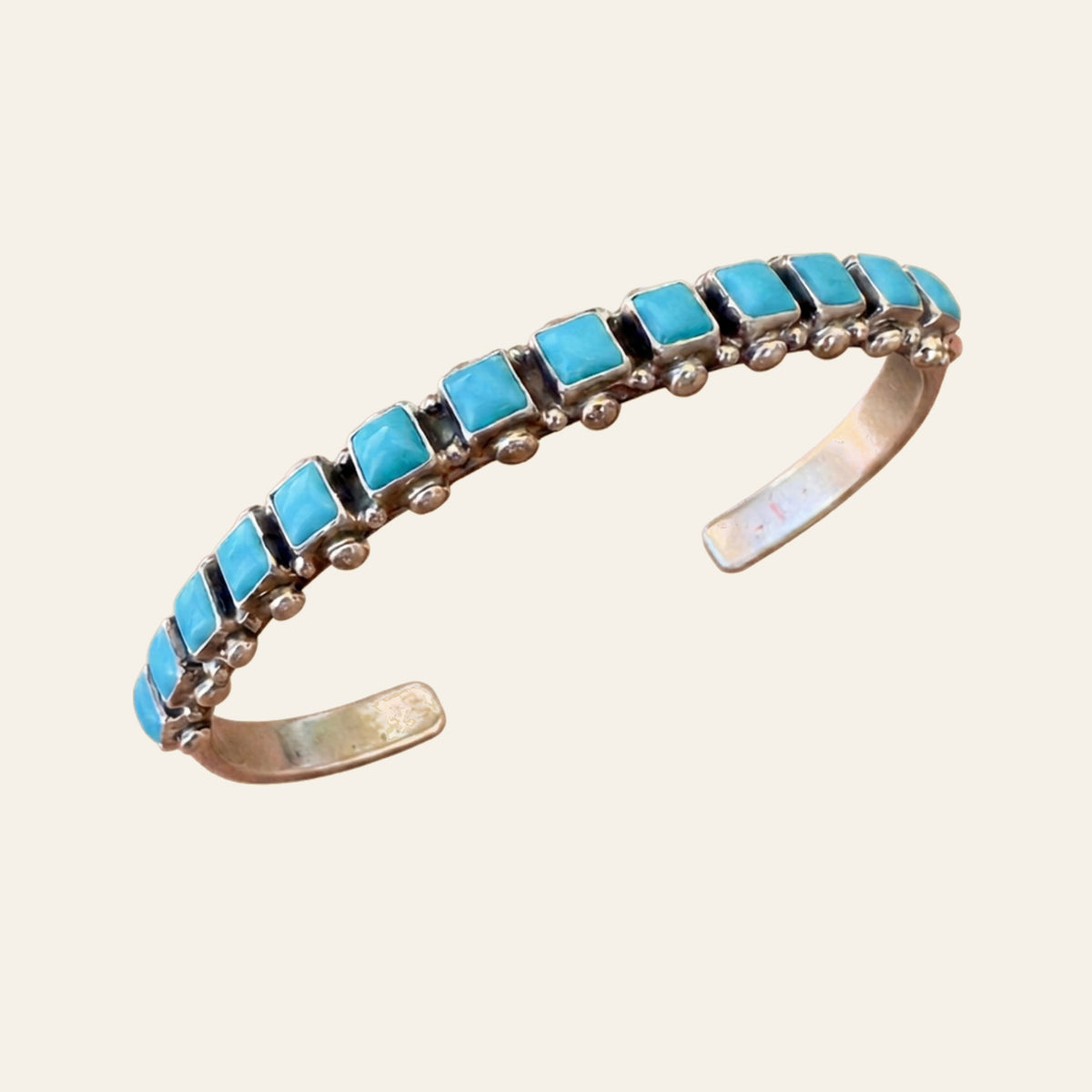 Sleeping Beauty Turquoise Row Bangle in Sterling Silver, by Don Lucas, shown on a cream background