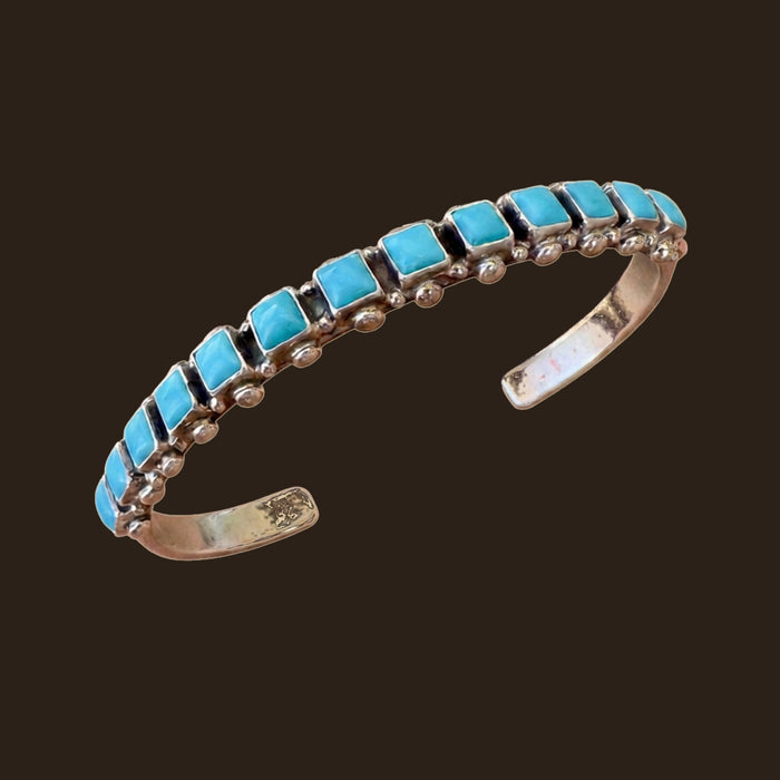 Sleeping Beauty Turquoise Row Bangle in Sterling Silver, by Don Lucas, shown on an espresso background