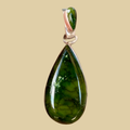 Sonoran Mountain Turquoise Teardrop Pendant in Sterling Silver, by Martinez, shown on a desert plaster background