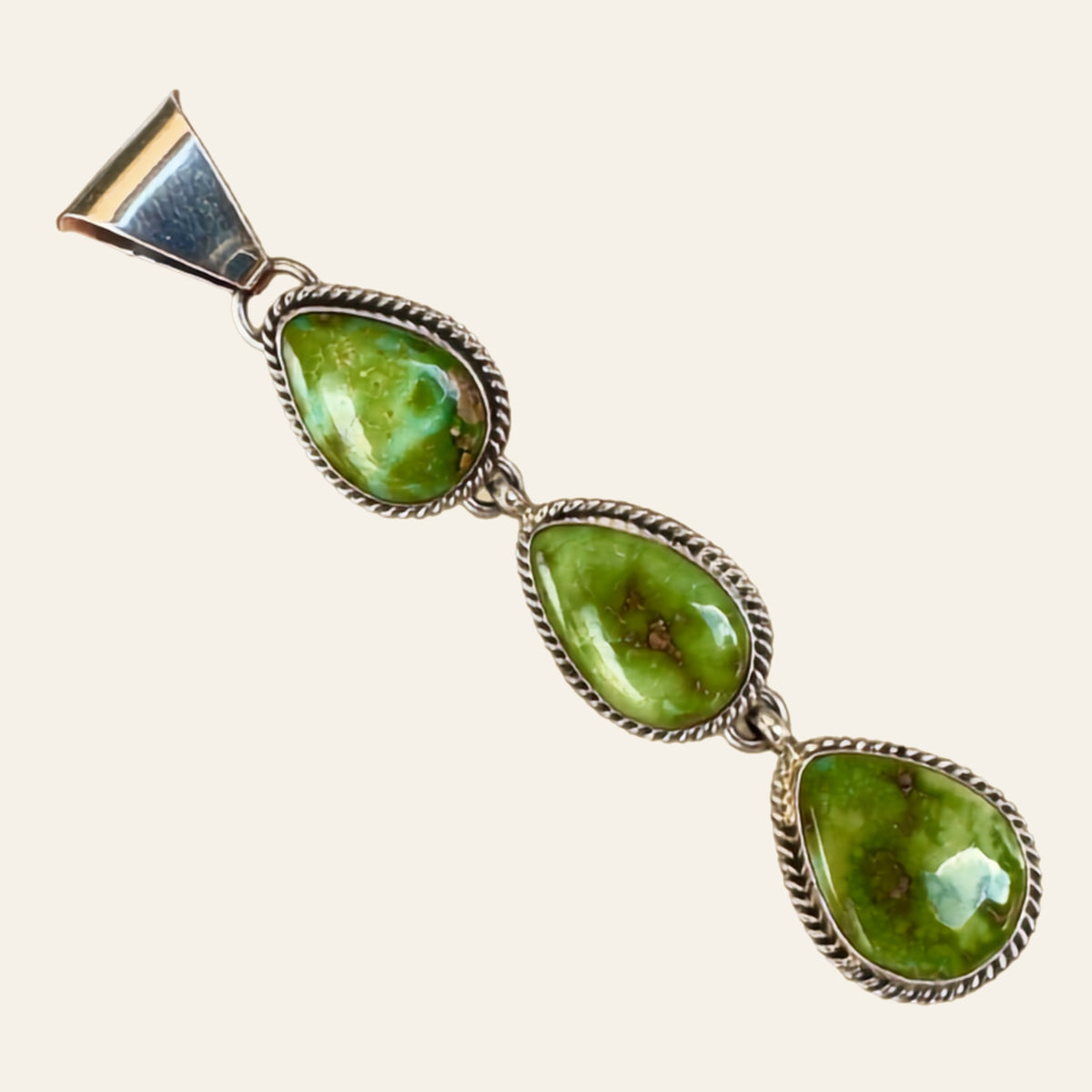 Sonoran Mountain Turquoise Triple Teardrop Pendant in Sterling Silver, by C. Wylle, shown on a cream background
