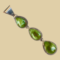 Sonoran Mountain Turquoise Triple Teardrop Pendant in Sterling Silver, by C. Wylle, shown on a desert plaster background