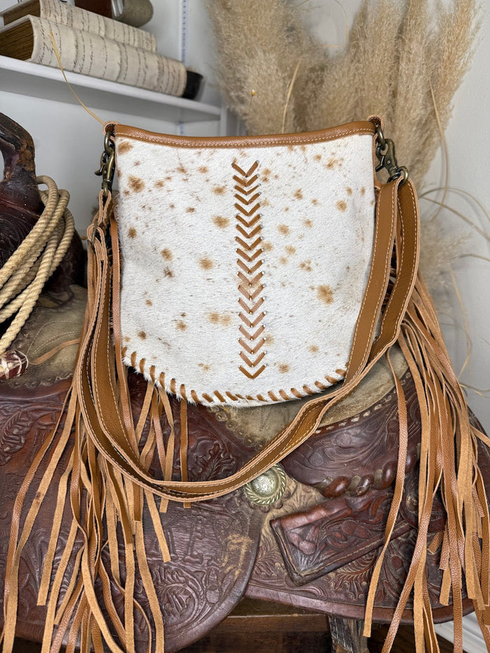 Western shoulder bag in white and cinnamon speckled hair-on cowhide with tan leather chevron lacing and long side fringe