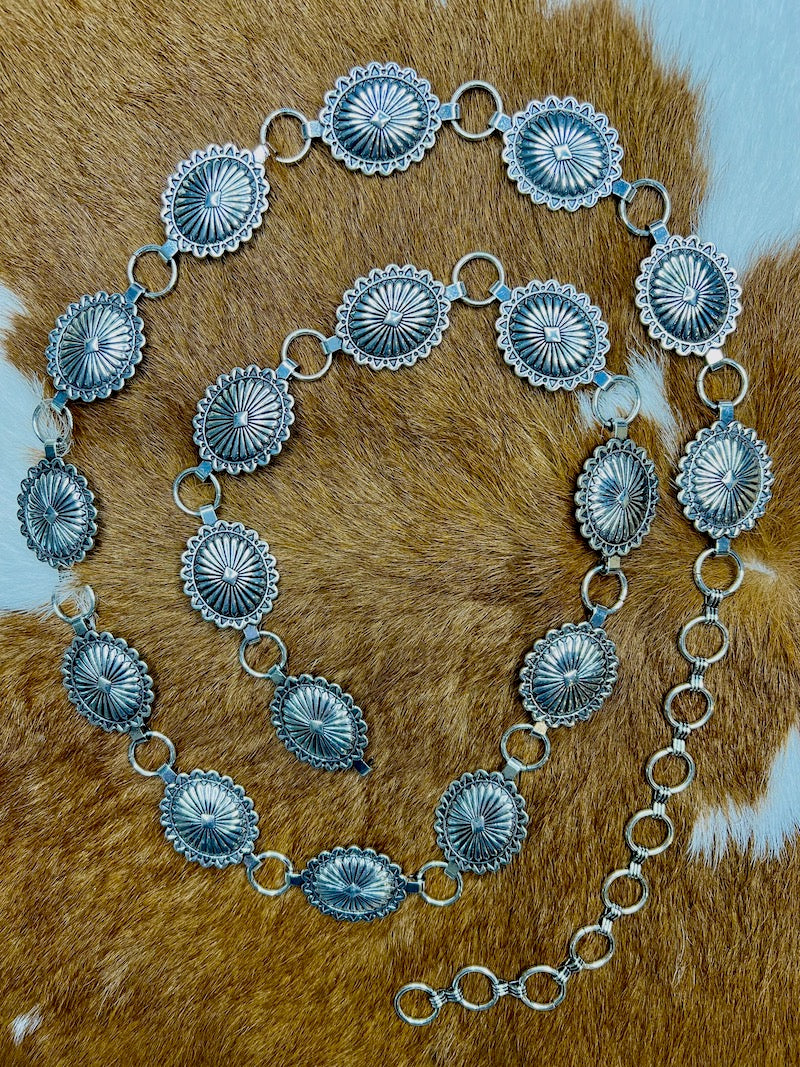 Detail of the sunburst stamping and scalloped border on the silver conchos