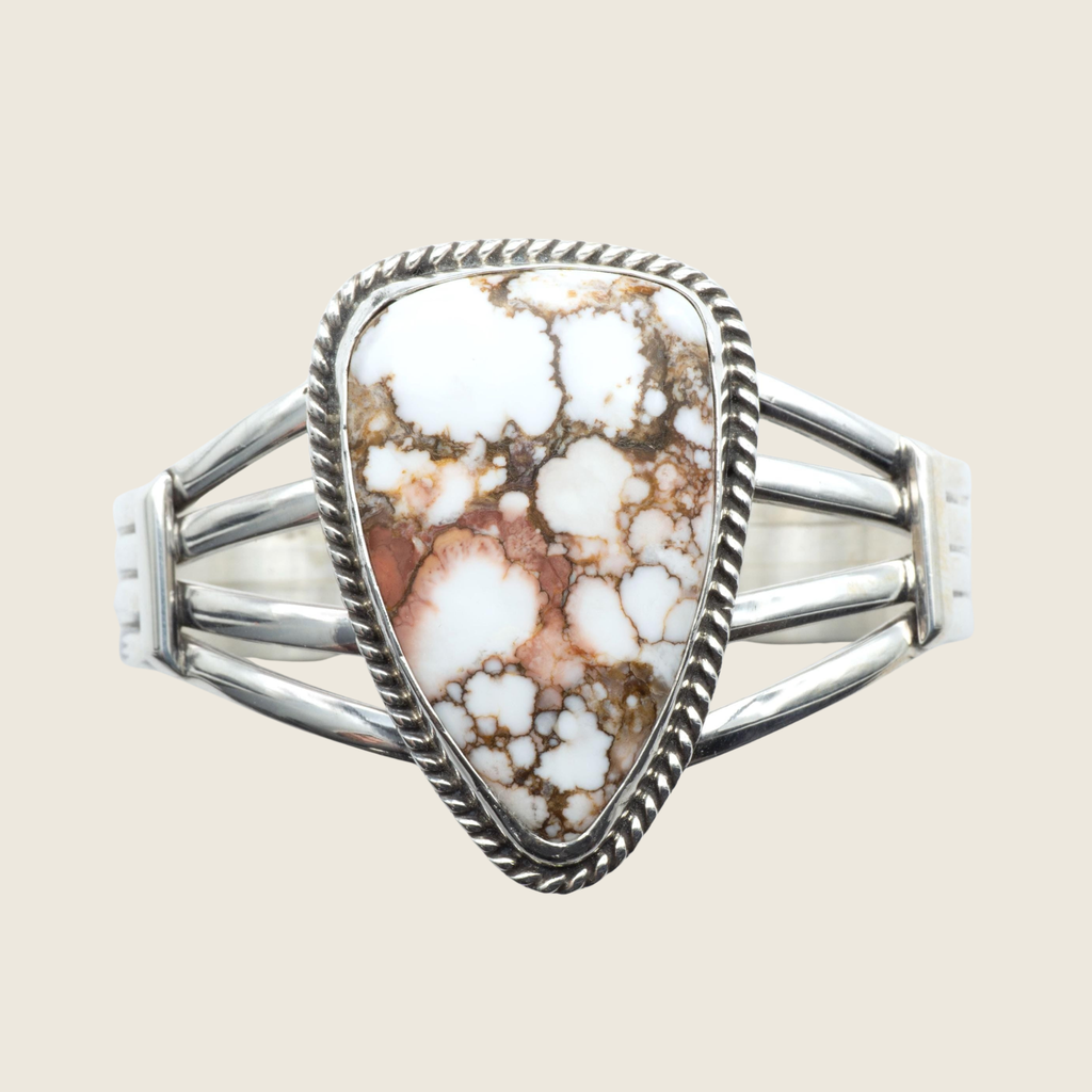 Wild horse rope edge cuff bracelet in Navajo sterling silver by P. Yazzie, shown on a bone linen background