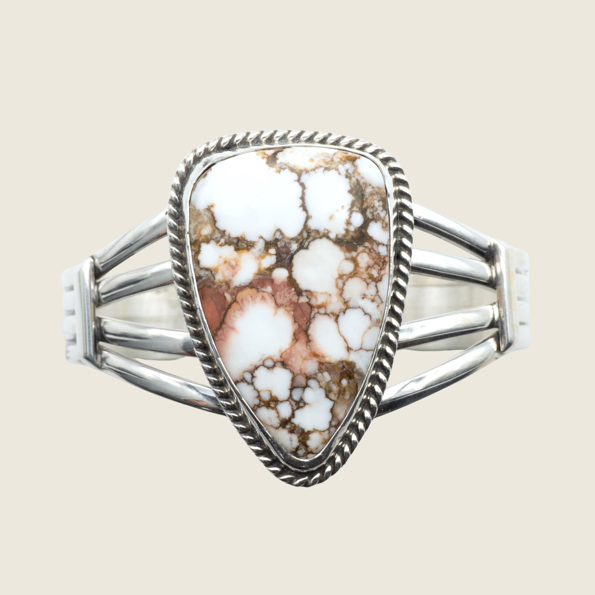 Wild horse rope edge cuff bracelet in Navajo sterling silver by P. Yazzie, shown on a bone linen background