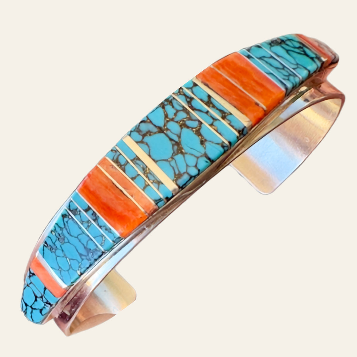 Turquoise and Spiny Oyster Channel Inlay Cuff Bracelet in Sterling Silver, shown on a cream background
