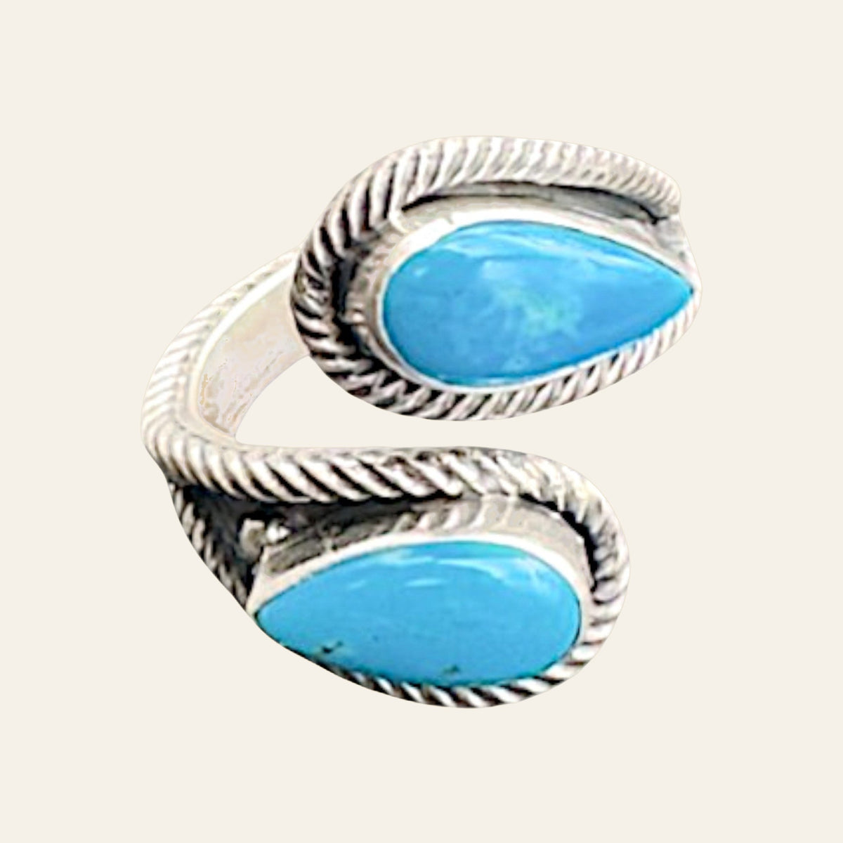 Turquoise Bypass Ring in Zuni Sterling Silver, by Kenny Lonjose, shown on a cream background