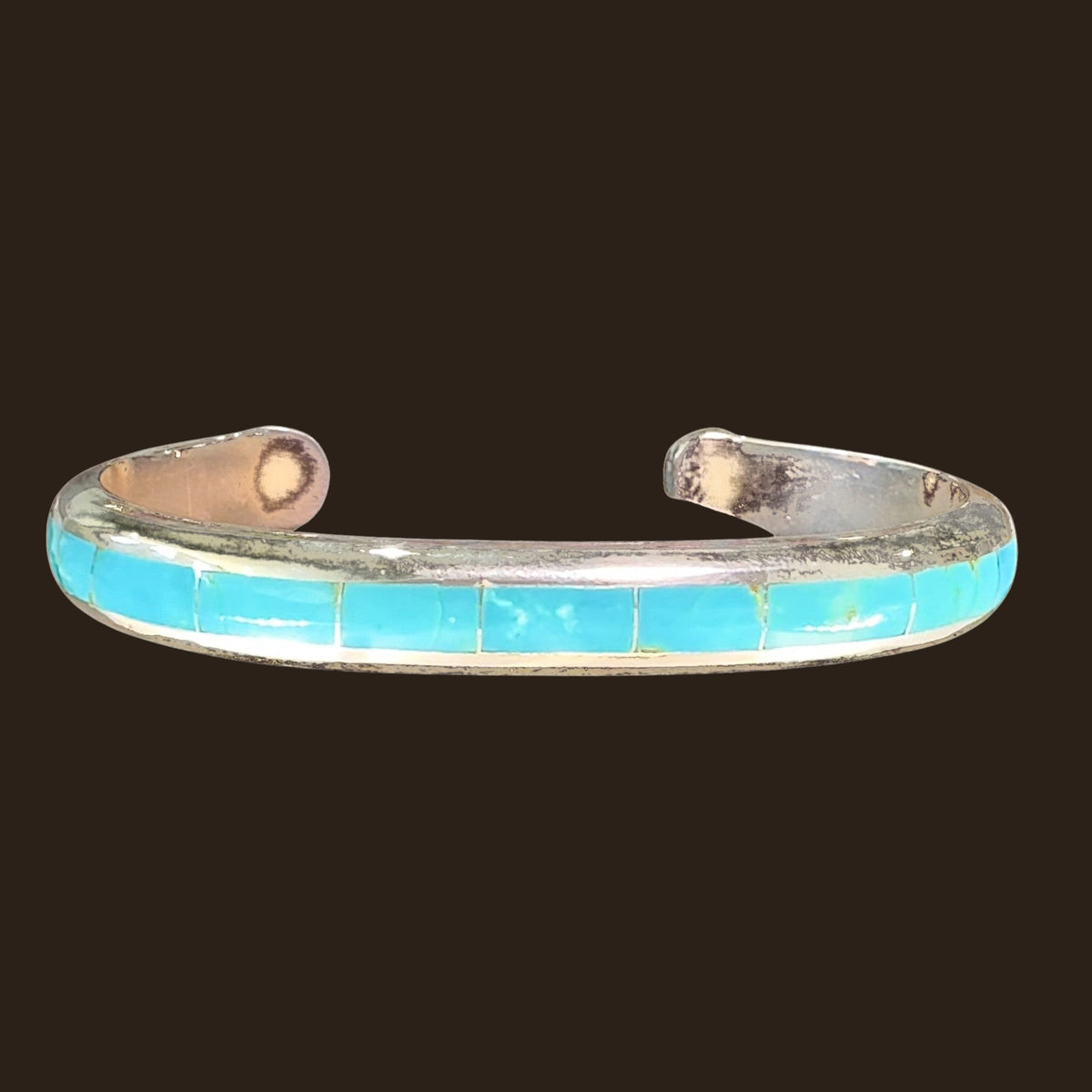 Turquoise Channel Inlay Cuff Bracelet in Zuni Sterling Silver, by Johnny Coonsis, shown on an espresso background