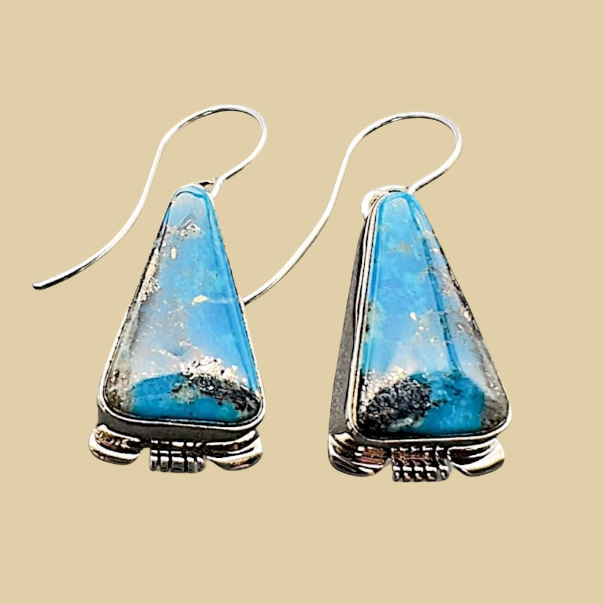 Turquoise Inlay Drop Earrings in Navajo Sterling Silver, by Larry Moses Yazzie, shown on a desert plaster background