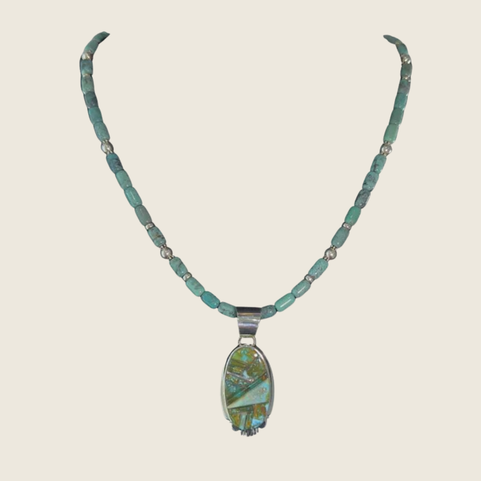 Green turquoise inlay pendant necklace in Navajo sterling silver by Rick Tolino, shown on a bone linen background