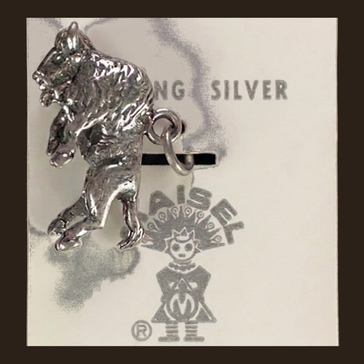 Vintage Maisel's Sterling Silver Buffalo Charm, New Old Stock, shown on an espresso background
