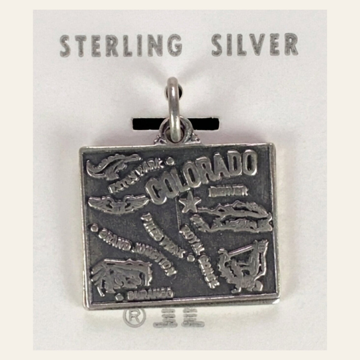 Vintage Maisel's Sterling Silver Colorado Map Charm, New Old Stock, shown on a cream background