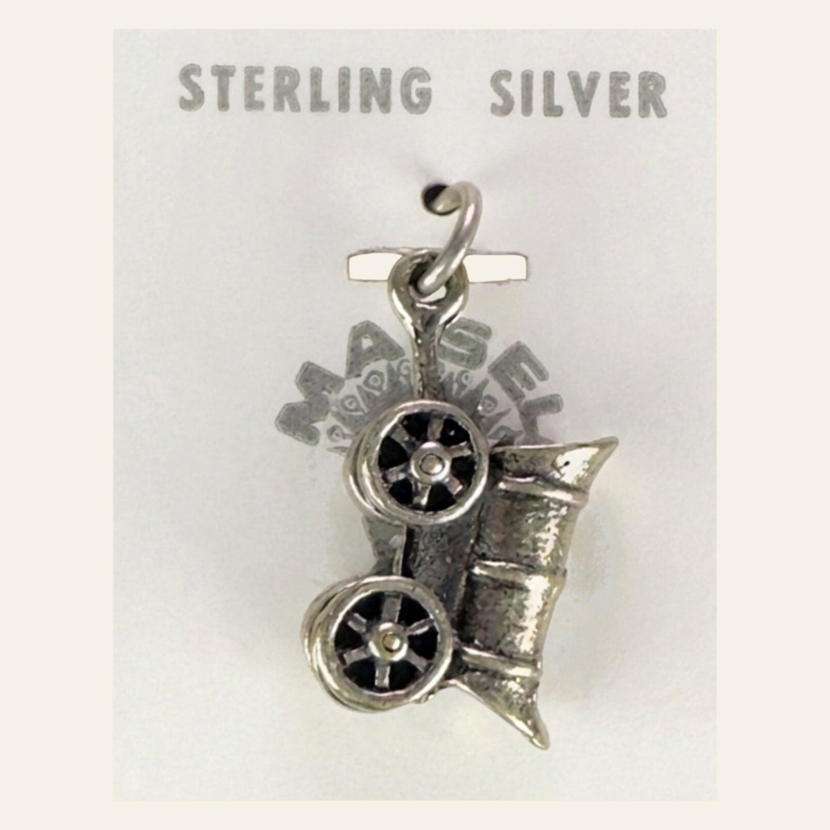 Vintage Maisel's Sterling Silver Covered Wagon Charm, New Old Stock, shown on a cream background