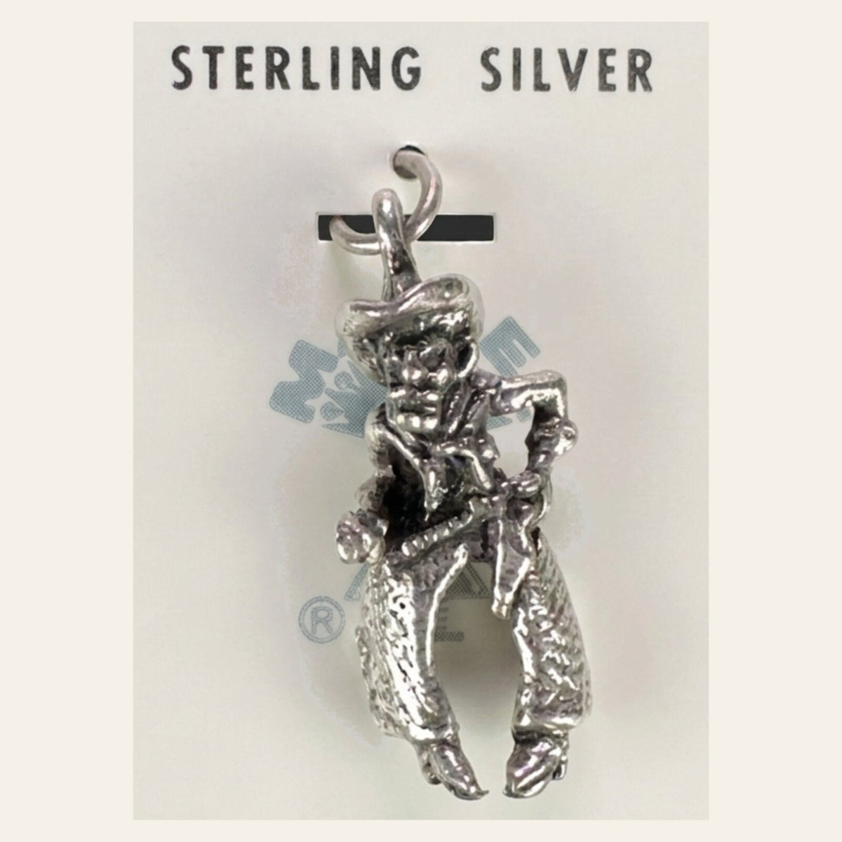 Vintage Maisel's Sterling Silver Cowboy Charm, New Old Stock, shown on a cream background
