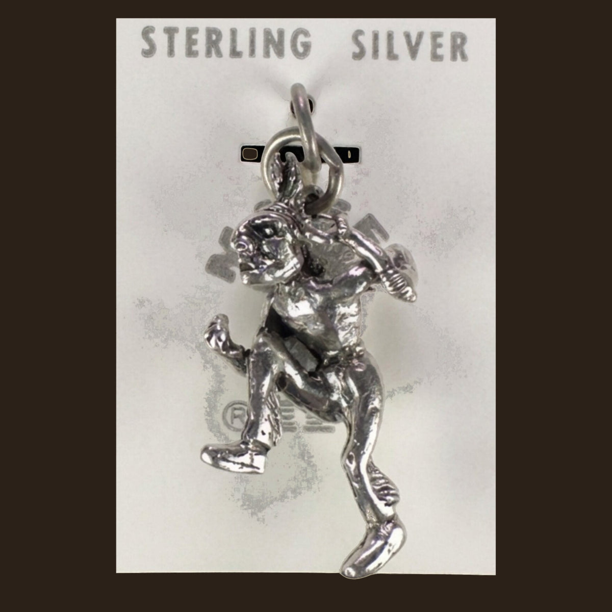 Vintage Maisel's Sterling Silver Dancer Charm, New Old Stock, shown on an espresso background