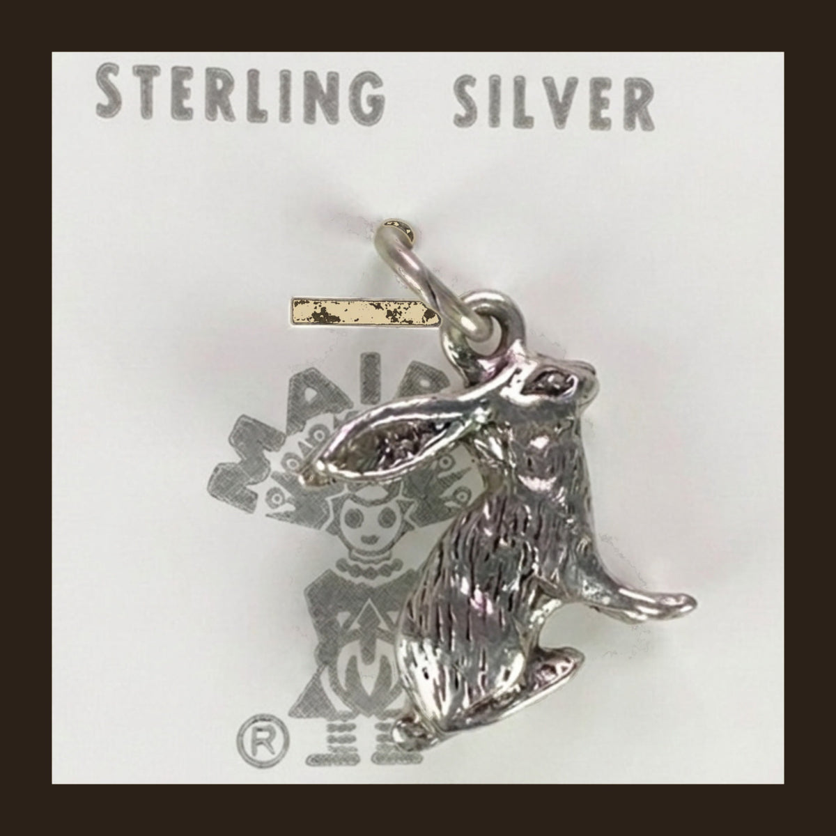 Vintage Maisel's Sterling Silver Jackrabbit Charm, New Old Stock, shown on an espresso background