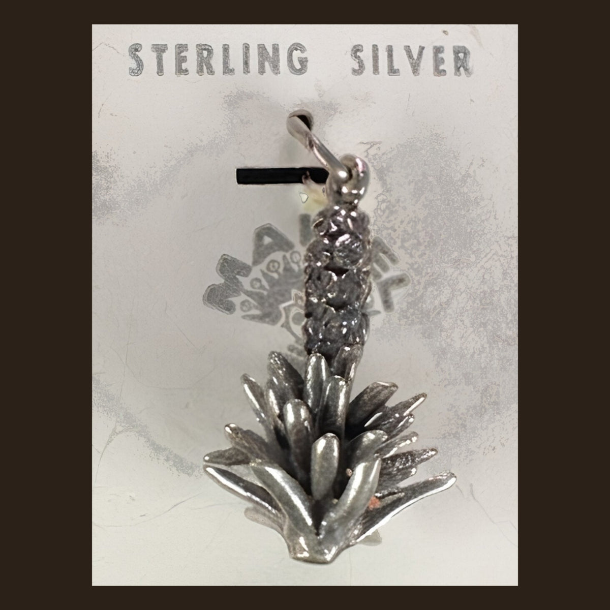 Vintage Maisel's Sterling Silver Yucca Charm, New Old Stock, shown on an espresso background