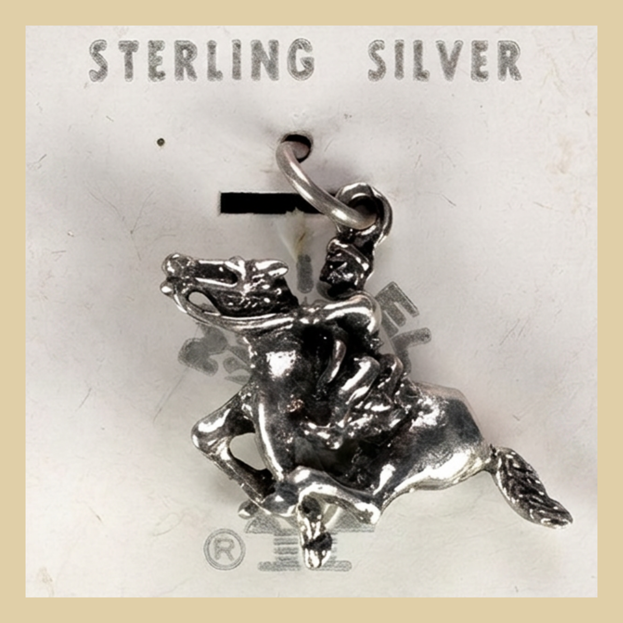 Vintage Maisel's Sterling Silver Bucking Bronco Charm, New Old Stock, shown on a desert plaster background