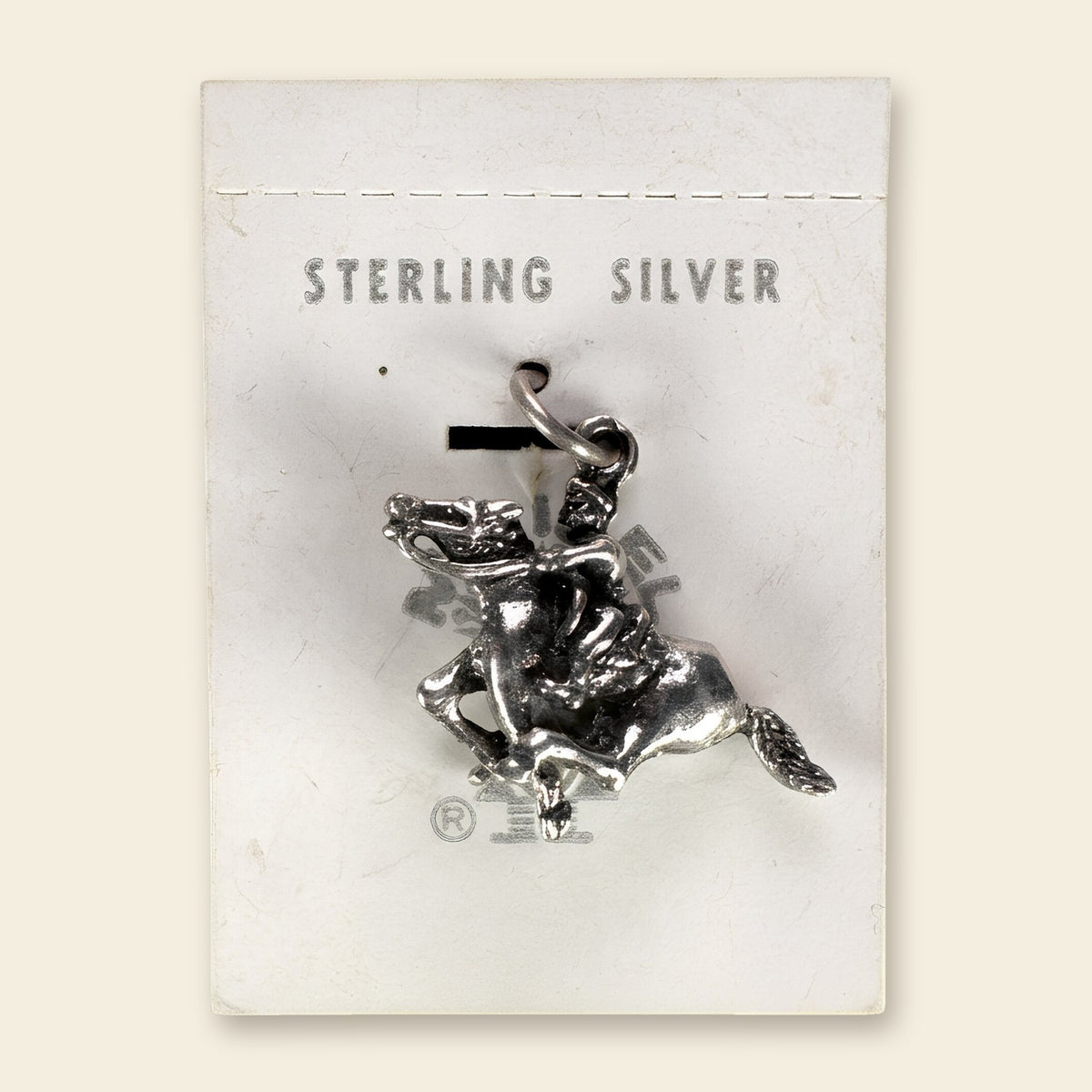 Vintage Maisel's Sterling Silver Bucking Bronco Charm, New Old Stock, shown on an ivory background