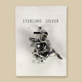 Vintage Maisel's Sterling Silver Bucking Bronco Charm, New Old Stock, shown on a sand background