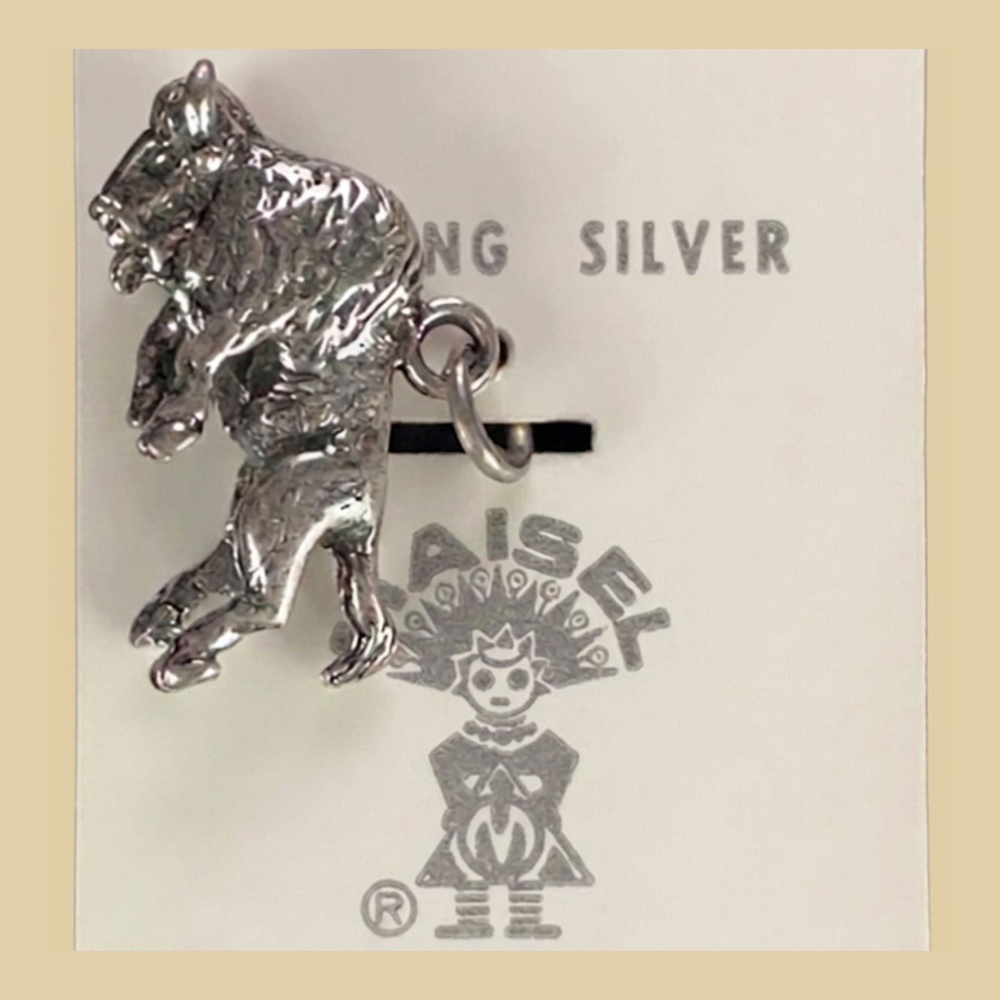 Vintage Maisel's Sterling Silver Buffalo Charm, New Old Stock, shown on a desert plaster background