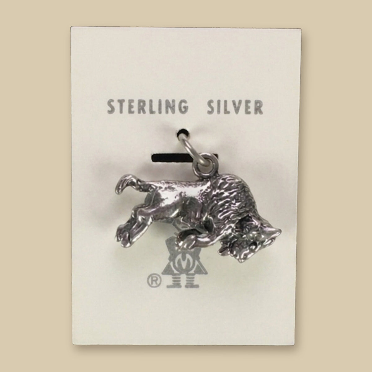 Vintage Maisel's Sterling Silver Buffalo Charm, New Old Stock, shown on a sand background