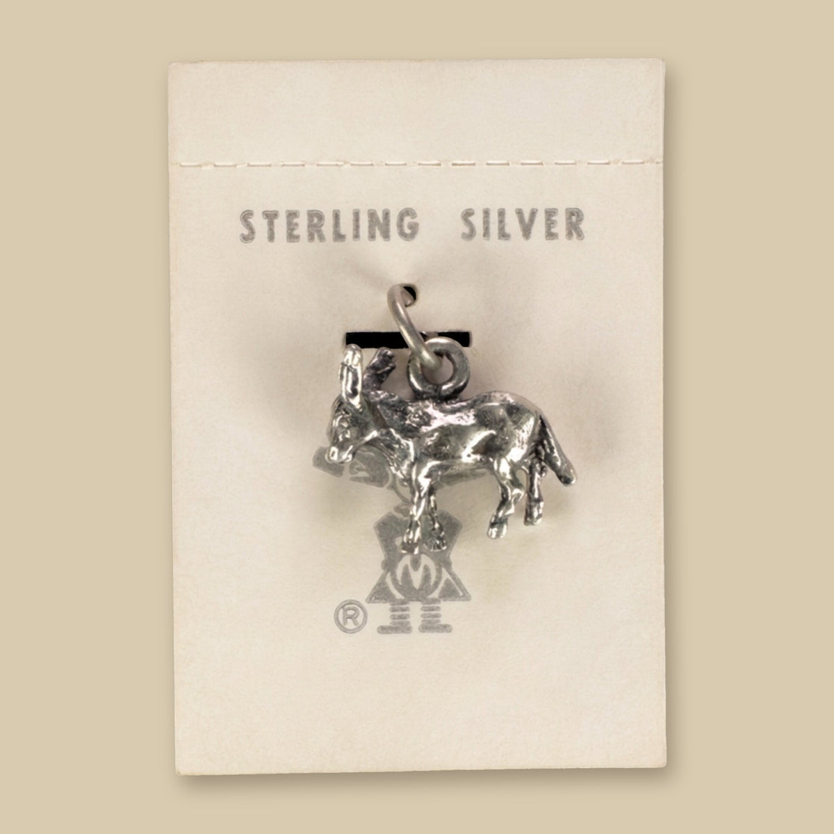 Vintage Maisel's Sterling Silver Burro Charm, New Old Stock, shown on a sand background