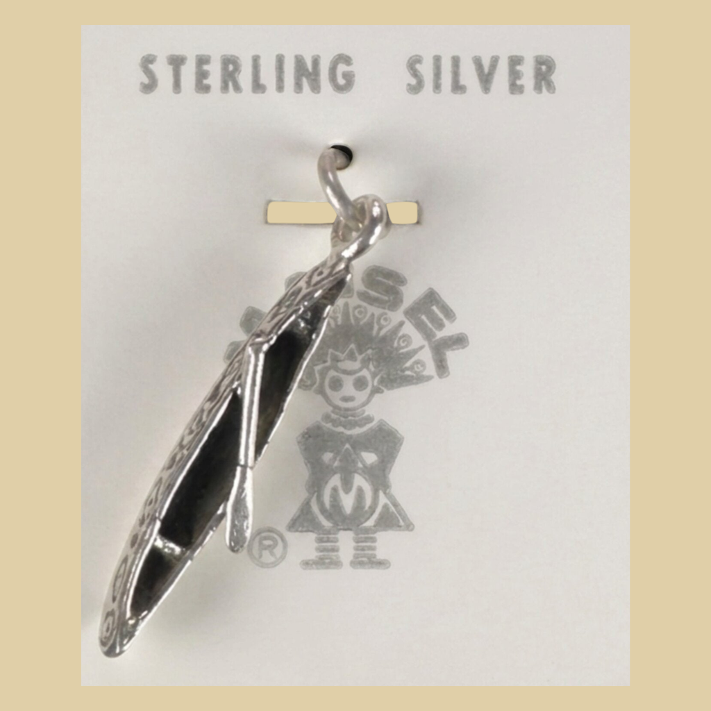 Vintage Maisel's Sterling Silver Canoe Charm, New Old Stock, shown on a desert plaster background