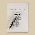 Vintage Maisel's Sterling Silver Canoe Charm, New Old Stock, shown on a sand background