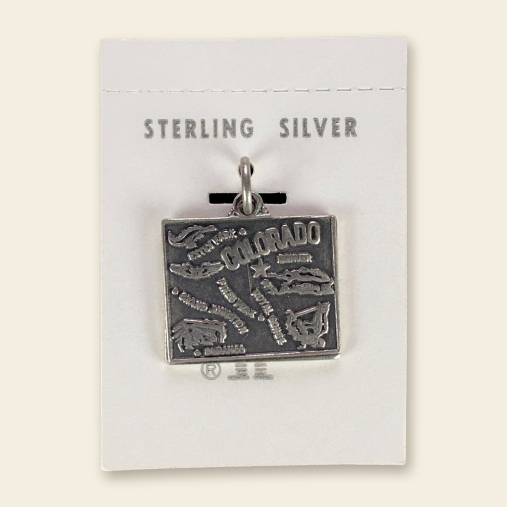 Vintage Maisel's Sterling Silver Colorado Map Charm, New Old Stock, shown on an ivory background
