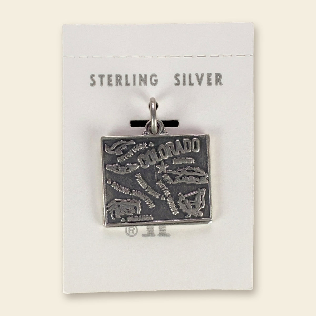 Vintage Maisel's Sterling Silver Colorado Map Charm, New Old Stock, shown on an ivory background